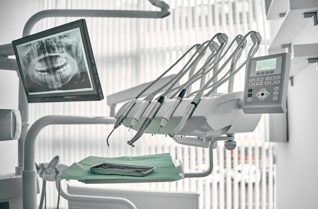Dental office equipment with X-ray display, dental tools, and instruments; modern stomatology setup.
