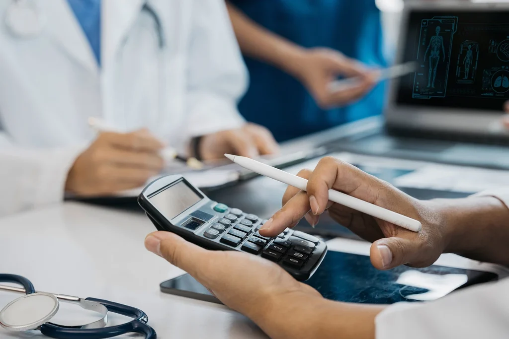 Patient paying for dental care with a card and calculator
